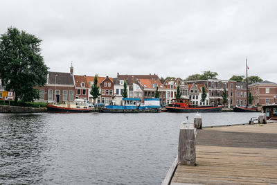 Boats in harbor against sky