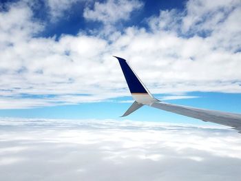 Close-up of airplane flying over sea against sky