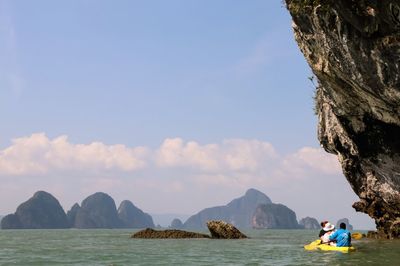 Rear view of people canoeing in lake