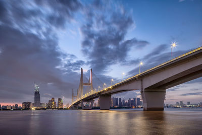 View of bridge over city at night