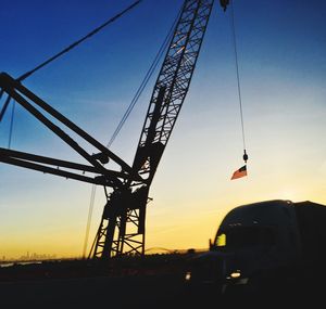 Silhouette of cranes against sky