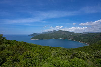 Scenic view of sea and mountains against blue sky