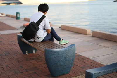 Rear view of woman sitting on bench