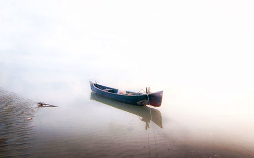 Boat moored on sea against sky