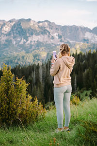 Full length of woman photographing on mountain