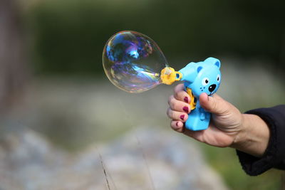 Close-up of woman hand making bubble from wand