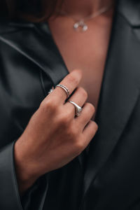 Close up fashion details of a black leather jacket and silver ring accessories. fancy outfit