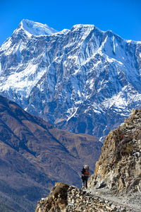 Woman climbing on mountains against sky