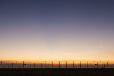 Scene of sky after sunset behind security barbed wire fence