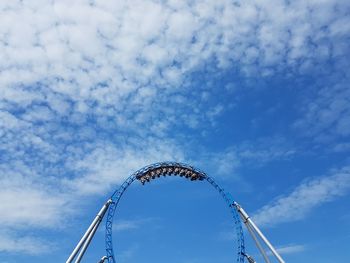 Low angle view of ferris wheel against blue sky