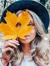 Portrait of woman holding autumn leaf