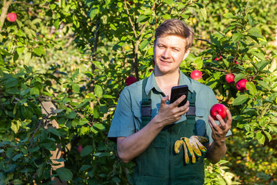 Portrait of smiling young woman holding flowers