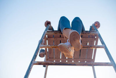 Low angle view of man relaxing against blue sky
