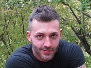 Portrait of young man against trees