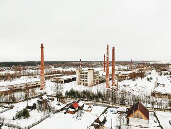 Snow covered buildings against sky during winter