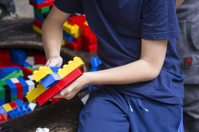 Midsection of boy playing with colorful toy blocks