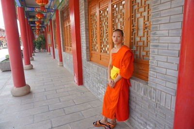 Portrait of smiling man standing against orange building