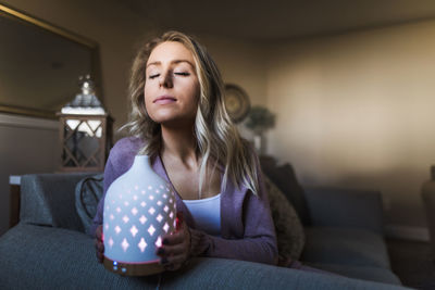 Portrait of woman sitting on sofa at home