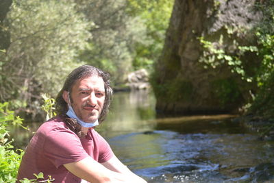 Portrait of mature man in lake against trees