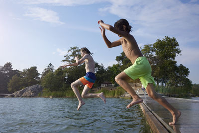 Boys jumping into water