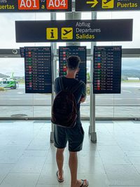 Rear view of man standing at airport