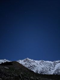 Scenic view of snowcapped mountains against sky at night