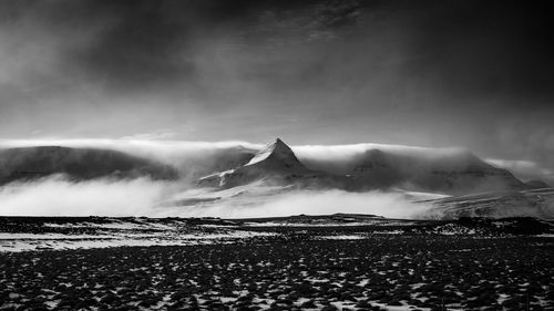 Scenic view of mountains against cloudy sky