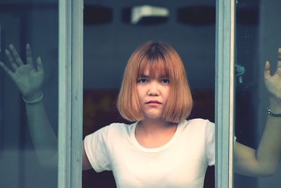 Portrait of cute girl standing by window