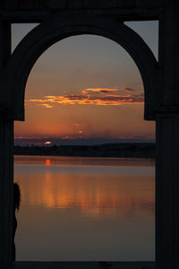 Reflection of clouds in sea at sunset