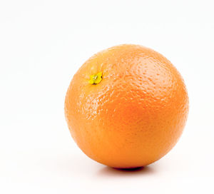 Close-up of orange apple against white background