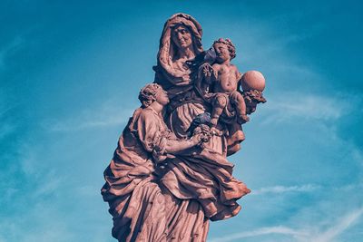 Low angle view of angel statue against sky