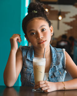 Portrait of young woman drinking glass