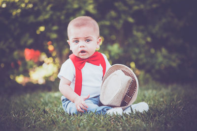 Portrait of cute girl sitting on field