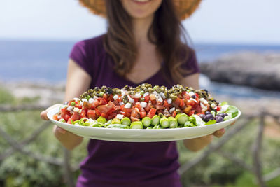 Midsection of woman holding food outdoors