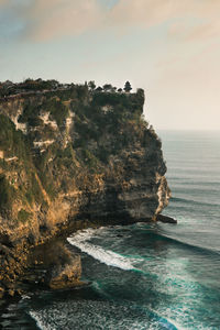 Rock formation on sea against sky