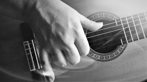 Midsection of man playing guitar