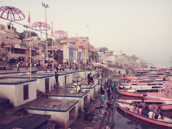 Boats moored in city against clear sky