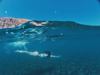 Woman swimming underwater in sea