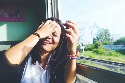 Smiling woman sitting by window in train