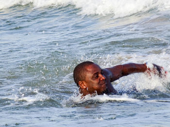 Shirtless man swimming in sea