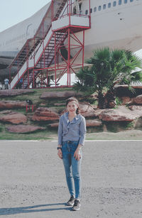 Full length portrait of teenage boy standing against built structure