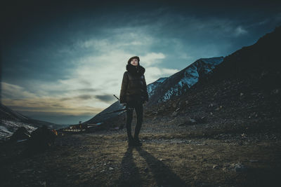 Woman standing on mountain against sky