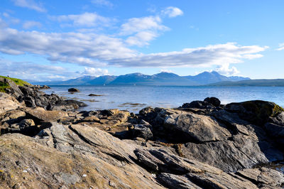 Scenic view of sea and mountains against sky