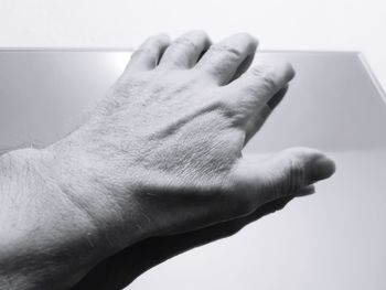 Close-up of hand touching finger against white background