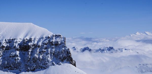 Scenic view of snow mountains against blue sky