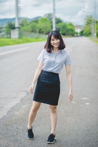 Young woman standing on road in city