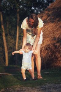 Mother and baby son making first steps