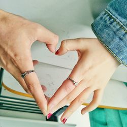 Close-up of couple making heart shape