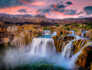 Scenic view of shoshone falls waterfall against sky during sunset