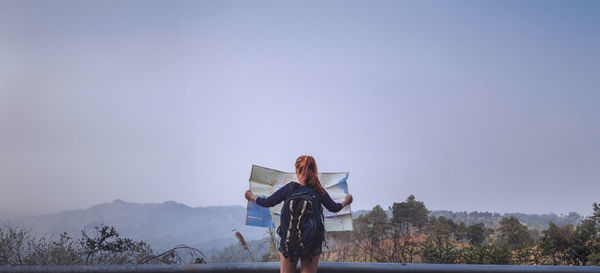 Rear view of man standing against sky